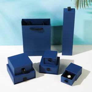 Detailansicht von blauen Schmuck-Geschenkboxen in verschiedenen Größen mit passender Papiertüte