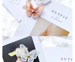 Close-up of delicate lace butterfly embroidery and pearl detail on soft white background