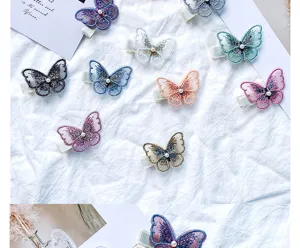 Detail of delicate embroidered butterfly hair clips with center pearl accents.