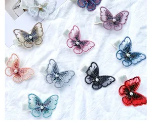 Close-up of colorful embroidered butterfly hair clips featuring elegant white pearls