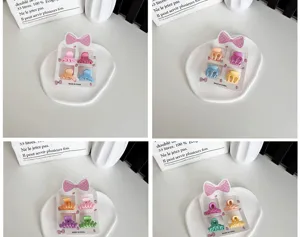 Lot de quatre mini pinces à cheveux aux couleurs acidulées pour filles sur fond blanc