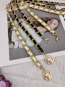 Detailed view of the luxury leather interwoven metal waist chain with vintage coin pendants.