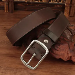 Close-up detail of a vintage brown genuine leather belt featuring a classic silver pin buckle.