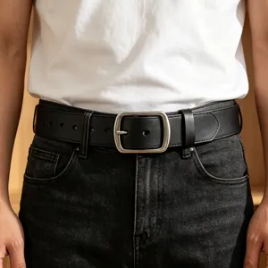Close-up of a vintage black leather belt with a classic silver pin buckle on jeans