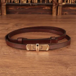 Smalle leren damesriem met gouden draaisluiting, minimalistisch stijlvol jurk accessoire.