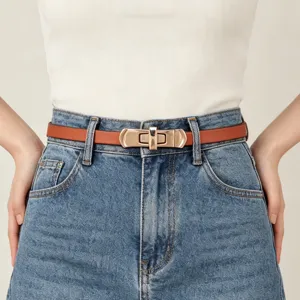 Close-up van een smalle bruine lederen damesriem met metalen draaisluiting op jeans.