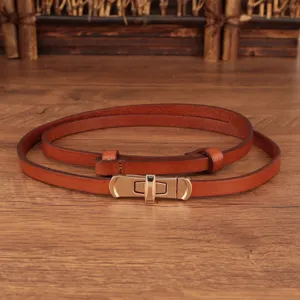 Smalle bruine lederen damesriem met elegante metalen draaisluiting detailopname