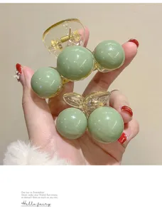 Close-up of sage green minimalist hair claw clips in large and small sizes