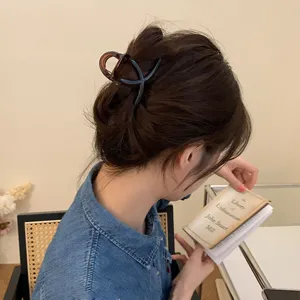 Pince à cheveux minimaliste de 8 cm marron foncé pour un chignon élégant de femme.