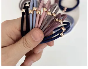 Detail shot of multi-color elastic hair ties with elegant rose gold bead accents.