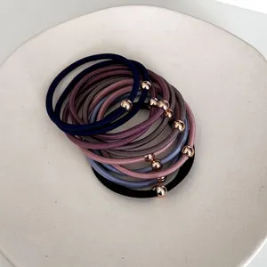 Minimalist high-elastic hair ties with rose gold beads in assorted matte colors on a white plate