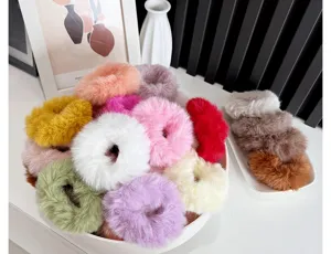 Detailed macro view of soft plush hair scrunchies in various vibrant pastel colors