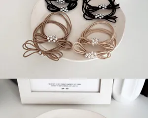 Detailed macro view of multi-strand elastic hair ties featuring elegant pearl beaded bow accents.