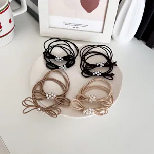 Set of pearl bow elastic hair ties in neutral colors on a white ceramic plate