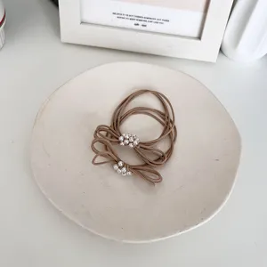 Set of pearl bow elastic hair ties in minimalist beige on ceramic display dish