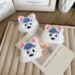 Three cute white plush West Highland Terrier dog brooches with blue hats on a tray
