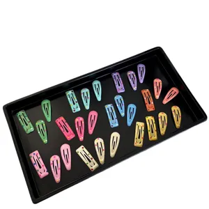 Mini colorful polka dot snap hair clips set for babies and pets on a black display tray