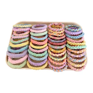 Large collection of vibrant multicolor braided high-elastic hair ties on display tray