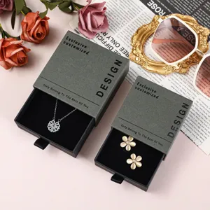 Λεπτομερής προβολή κομψού γκρι κουτιού δώρου κοσμημάτων με χρυσή μεταξοτυπία κειμένου