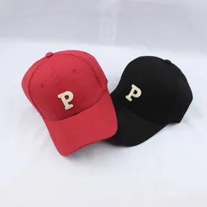 Close-up detail of casual baseball caps featuring letter P embroidery, red and black styles.