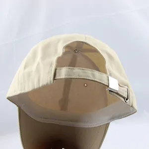 Close-up view of the adjustable metal buckle and breathable interior of a beige baseball cap