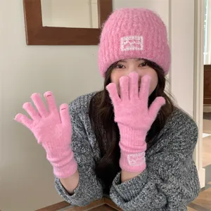 Pink knit hat and fingerless gloves set with cute lace label detail for cozy winter wear.