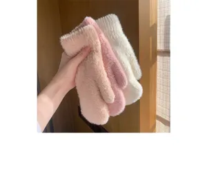 Primo piano di soffici guanti invernali in peluche, con consistenza accogliente e materiale.