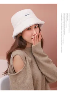Detailed view of white fuzzy shearling bucket hat for women autumn winter warm cap.