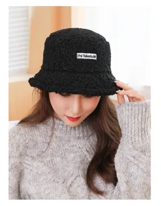 Black lamb wool bucket hat detail, warm fuzzy texture, stylish letter patch design.