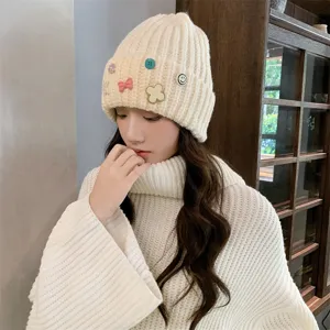 Closeup of cute women's winter knit beanie hat, thick warm plush style with sweet pins.