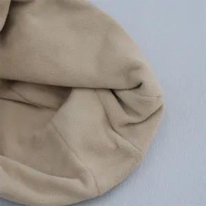 Close-up detail of soft beige fleece lining fabric, showing warm texture and fine stitching.