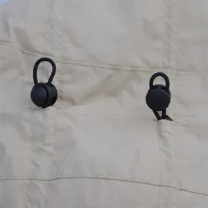 Detail view of winter outdoor hat drawstring and adjustable buckle, windproof fabric design.