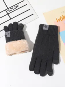 Detail view of winter warm knitted touch screen gloves with plush lining in dark grey.