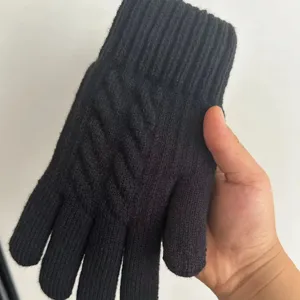 Close-up detail of black knitted winter thermal glove showing texture and ribbed cuff design.