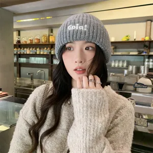 Fashionable grey winter knitted beanie with letter embroidery, cozy and warm casual style.