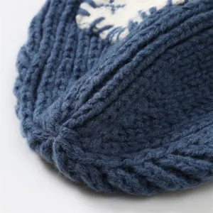 Nahaufnahme einer kuscheligen blauen Strickmütze mit Strukturmuster und Patch-Detail.