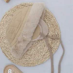 Beige quilted thermal bomber hat with plush faux fur trim and windproof ties for winter warmth.
