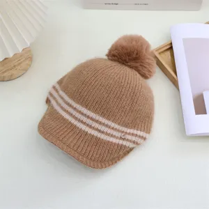 Winter women knitted pom pom hat with visor and cozy stripe design, detailed winter warm cap view.