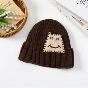 Gemütliche braune Strickmütze für Damen mit süßem Patch-Design, perfekt für den kalten Winter.