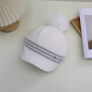 Close-up detail of the Japanese style striped knit beanie with fluffy pom-pom for women.