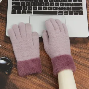 Close-up detail of winter warm knitted touch screen gloves with plush fluffy cuffs in pink.