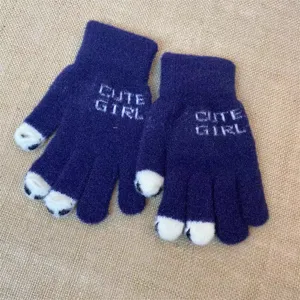 Close-up detail of dark blue knitted gloves featuring cute cat paw fingertips and knit text.