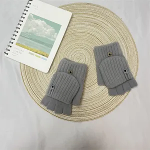 Detailed view of grey knit half-finger gloves featuring a flip-top design and cute decor tag.
