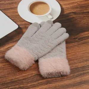 Close-up detail of winter warm knit touchscreen gloves with soft pink faux fur cuffs.