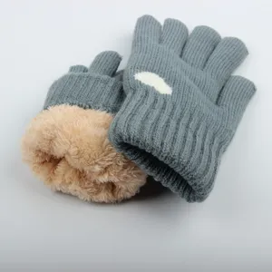 Detailed view of thick knitted warm winter gloves with soft plush lining and cute cloud pattern