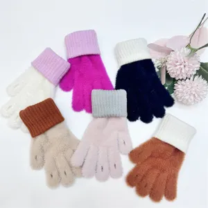 Primo piano di soffici guanti invernali lavorati a maglia con polsini lunghi e vari colori.