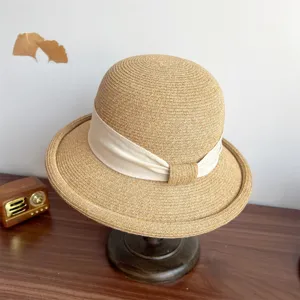 Detailed view of the elegant French style straw sun hat with beige ribbon and rolled brim.