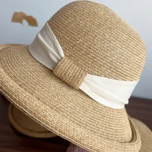 Detailed close-up of a stylish women's summer straw hat featuring a chic white ribbon bow.