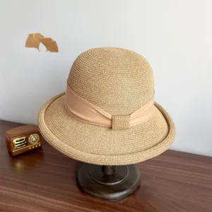 French straw sun hat with elegant bow, rolled edge summer beach cap for stylish women UV protection.