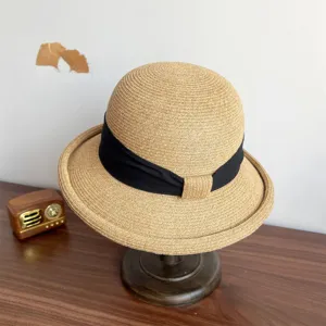 French style straw sun hat detail, curved brim with black ribbon, elegant summer hat.